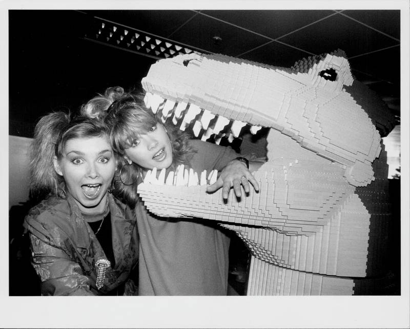 Bucks Fizz singers Cheryl Baker and Shelley Preston, posing in the mouth of a Lego dinosaur, in Debenhams department store, Croydon, November 7th 1985. (Photo by Keystone/Hulton Archive/Getty Images)