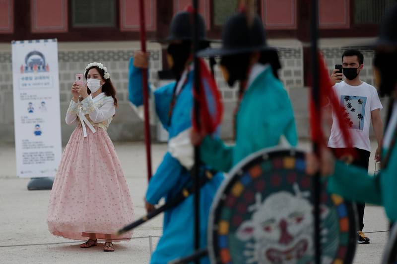Visitors hold their smartphones while maintaining social distancing during a re-enactment ceremony of the changing of the Royal Guard at the Gyeongbok Palace in Seoul, South Korea. AP Photo