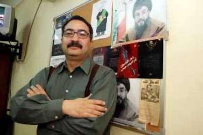 Ibrahim Eissa, Editor-in-chief of El-Destour, one of Egypts most controversial independent newspapers, stands in front of a picture of Hassan Nasrallah, whom he calls the Arab Che Guevara, as his desktop picture. May 12, 2008. 

Credit: Victoria Hazou for The National *** Local Caption ***  Nasrallah6.jpg