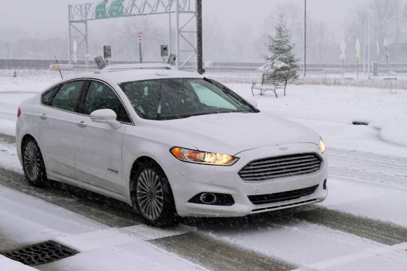 To navigate snowy roads, Ford autonomous vehicles are equipped with high-resolution 3D maps – complete with information about the road and what’s above it, including road markings, signs, geography, landmarks and topography. Ford is testing driverless Fusion sedans in snowstorms at the University of Michigan’s Mcity, a 32-acre (13-hectare) faux neighborhood for robot cars on the Ann Arbor school’s North Campus. Courtesy Ford Motor Co. *** Local Caption ***  bz14fe-world-feat-main-02.jpg