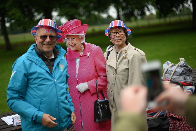 Participants pose for a picture with a cardboard cut-out of the queen on The Long Walk in Windsor. AFP