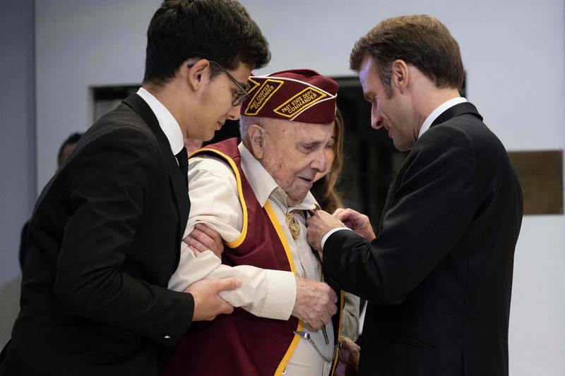Mr Macron awards Benjamin Portaro with the Legion d'Honneur. Mr Portaro was a prisoner of war in Europe during the Second World War. AFP