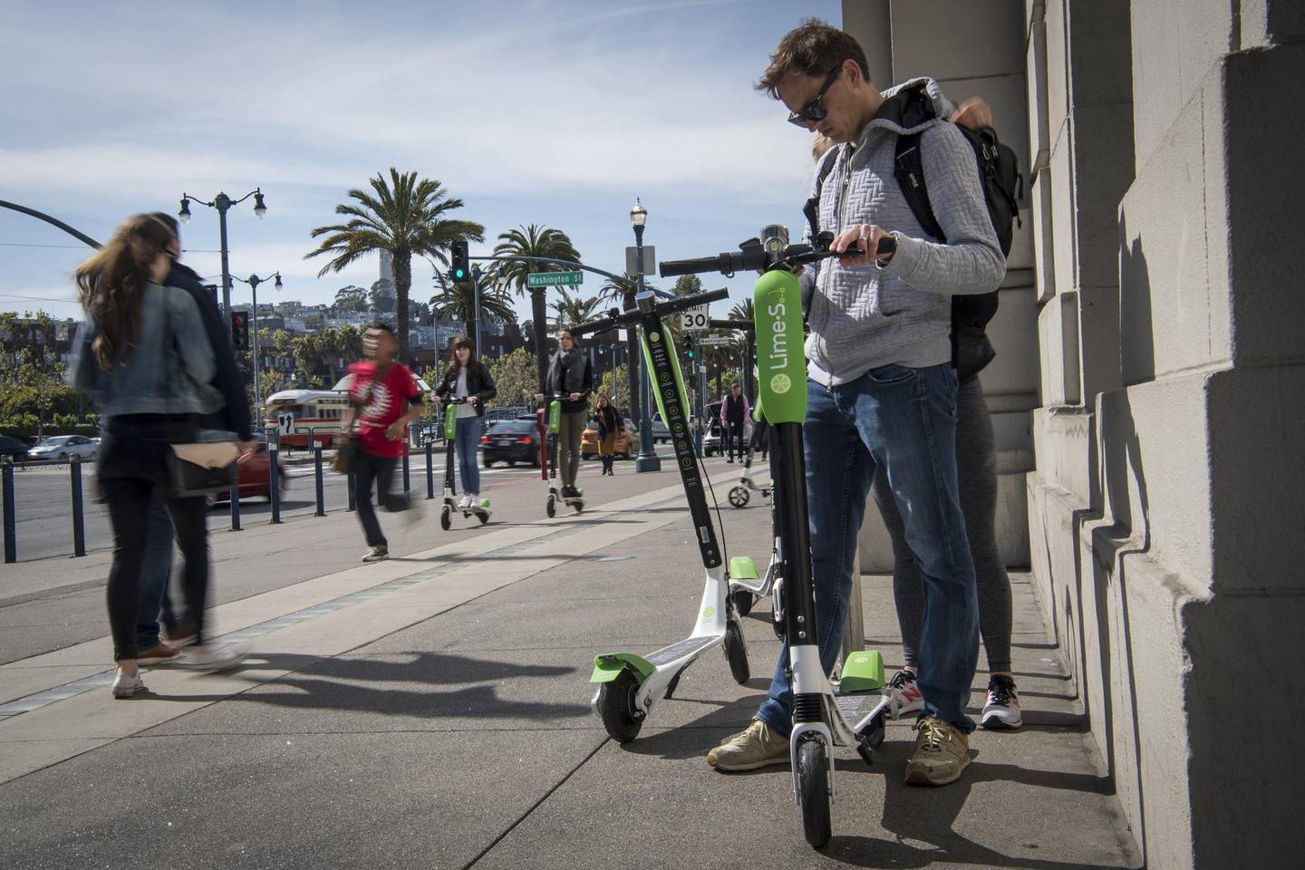 A person uses a smartphone to unlock Neutron Holdings Inc. LimeBike shared electric scooter on the Embarcadero in San Francisco, California, U.S., on Thursday, May 3, 2018. City officials, eager to do something about the electric scooters issue, are sending cease-and-desist letters and are planning to require permits soon, while impounding any that they say are parked illegally. Photographer: David Paul Morris/Bloomberg