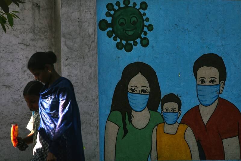 People walk past a Covid-19 mural in Chennai, India on April 11 amid a two-day nationwide drill to assess the preparedness of hospitals. EPA