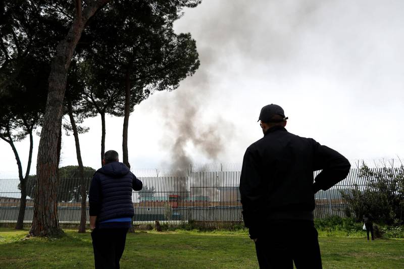 Relatives of inmates look at smoke inside Rebibbia Prison during a prisoners' revolt, after family visits were suspended due to fears over coronavirus contagion, in Rome, Italy March 9, 2020. REUTERS/Yara Nardi