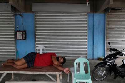 A man rests in front of closed shops in Agoncillo town in Batangas after most residents moved to safer areas.