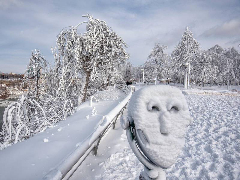 A coin operated binocular is covered in snow. James Neiss / The Niagara Gazette via AP