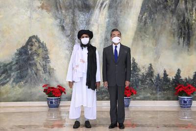 Taliban co-founder Mullah Abdul Ghani Baradar, left, and Chinese Foreign Minister Wang Yi pose for a photo during their meeting in Tianjin, China. AP