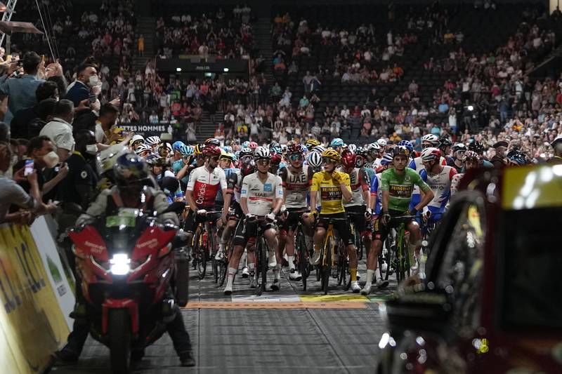 Tadej Pogacar, in white, Jonas Vingegaard, in yellow, and Wout Van Aert, in green, line-up in front of the peloton prior to the start of Stage 21. AP