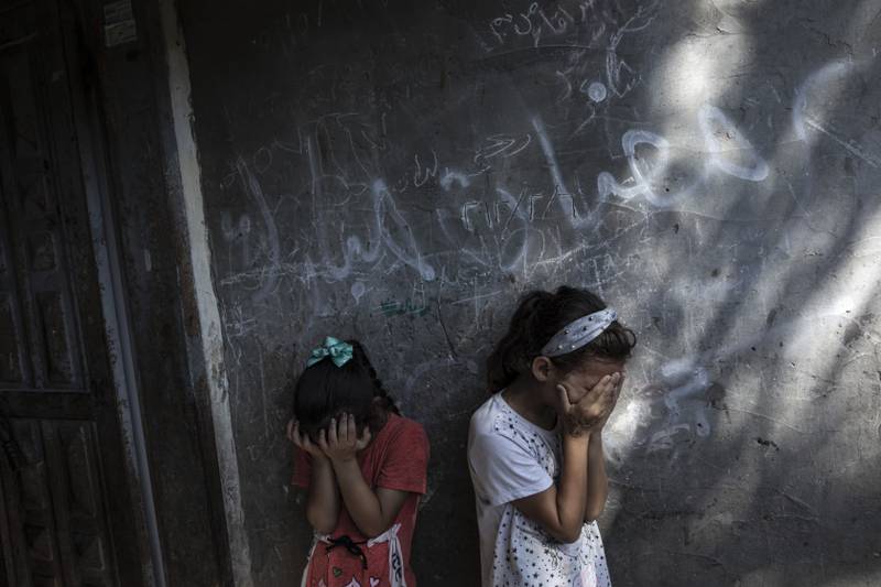 Young Palestinian girls are overcome at the funeral of 11-year-old Layan Al Shaer in Khan Younis, the Gaza Strip. She was killed in recent Israeli air strikes. AP