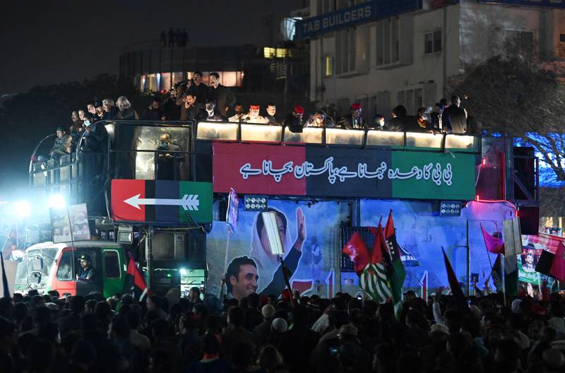 Supporters of the Pakistan Peoples Party gather around a lorry carrying Mr Bhutto Zardari in Islamabad. AFP