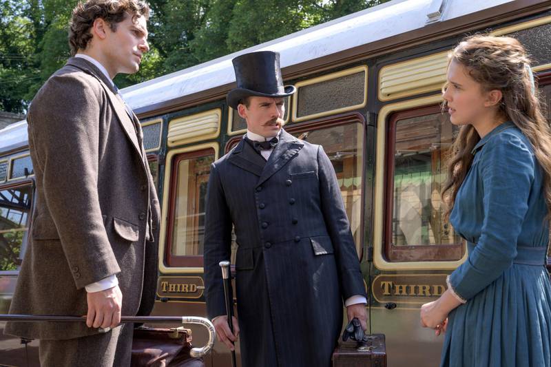 This image released by Netflix shows Henry Cavill, from left, Sam Claflin, and Millie Bobby Brown in a scene from "Enola Holmes." (Alex Bailey/Netflix via AP)