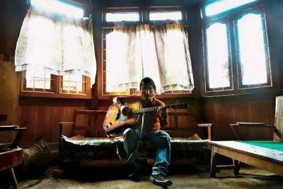 Jianngam Kamei, a popular local music director, plays his guitar in a room in Imphal, the capital of the north eastern Indian state of Manipur.