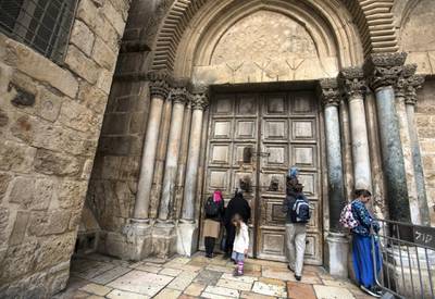Christian pilgrims pray by the closed wooden doors Church of the Holy Sepulchre in the Old City of Jerusalem on Monday February 26,2018.The Church of the Holy Sepulchre  remained closed for a second day after church leaders in Jerusalem closed it to protest against Israeli's announced plans by the cityÕs municipality earlier this month to collect property tax (arnona) from church-owned properties on which there are no houses of worship.
(Photo by Heidi Levine for The National).
