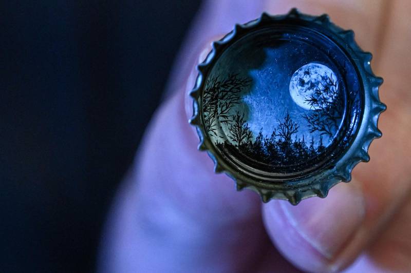 A moon landscape painted on a bottle cap