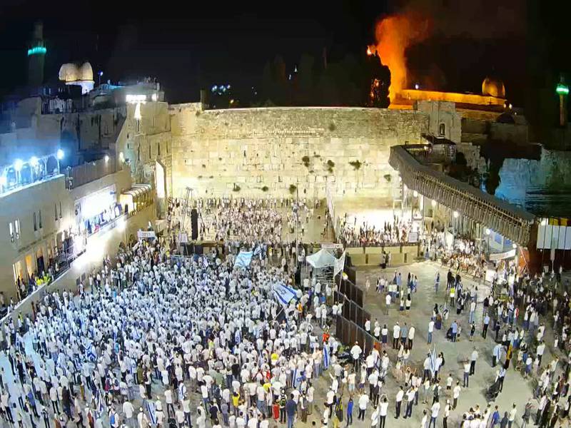Israelis gather at the Western Wall as a blaze is seen in the background at the Al Aqsa Mosque compound in Jerusalem's Old City. Reuters