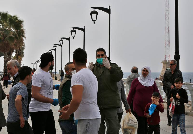 A municipal policeman, center, orders people to leave the waterfront promenade, along the Mediterranean Sea in Beirut. AP Photo