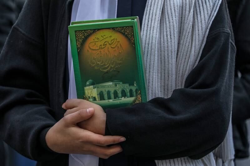 One of the pupils holds a copy of the Quran during the protest. EPA
