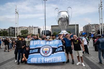 Manchester City fans pose for a photo in front of a replica of the Champions League trophy in Taksim Square. Getty 