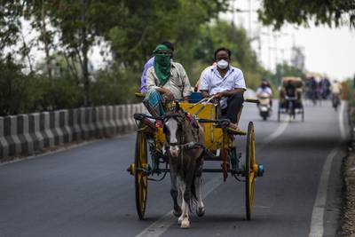 A horse drawn carriage takes passengers along a road during a partial lockdown imposed due to the coronavirus in New Delhi, India. Bloomberg