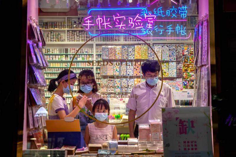 People wearing face masks to protect themselves against the coronavirus visit a store on a shopping street in Beijing. AP