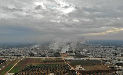 This picture taken on February 4, 2020 shows an aerial view of smoke plumes billowing from bombardment by the Syrian government forces and allies on the town of Sarmin, southeast of the city of Idlib in the northwestern province of the same name. (Photo by Omar HAJ KADOUR / AFP)