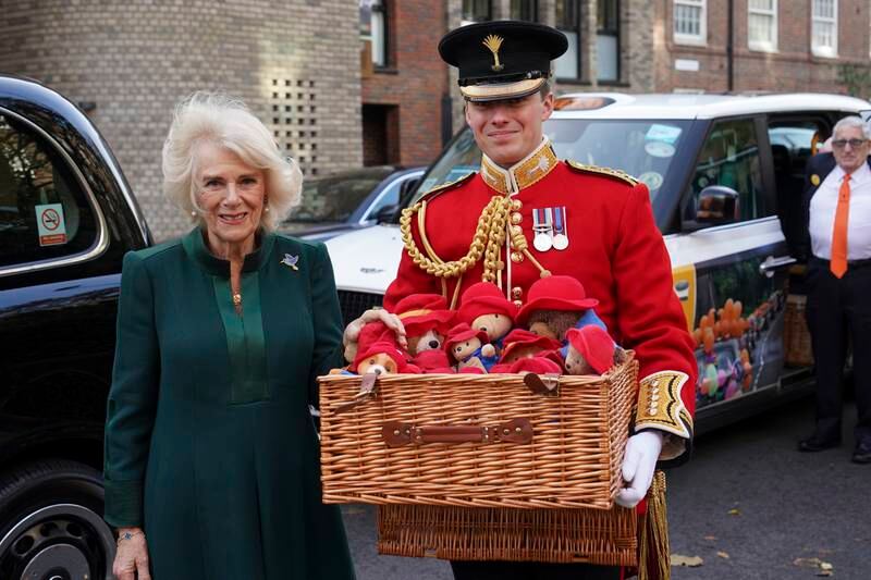 The queen consort Camilla, accompanied by a member of the Welsh Guards, arrives with the bears and other cuddly toys. Getty Images