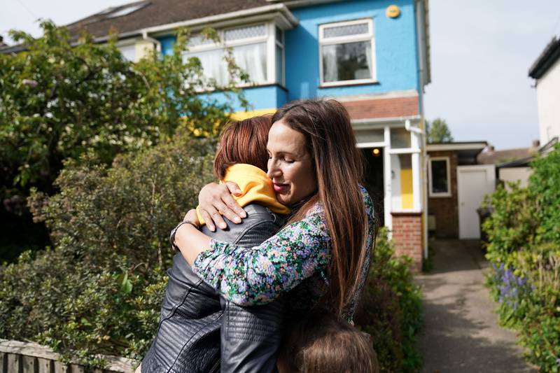 Campaigner Rend Platings, right, embraces her Ukrainian best friend Kristina Korniiuk as they are reunited outside her home in Cambridge. Ms Platings went on hunger strike until MsKorniiuk's UK visa was approved and painted her house in the colours of the Ukrainian flag. PA 