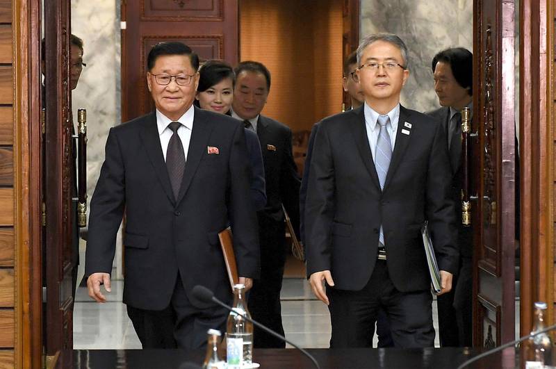 In this photo provided by South Korea Unification Ministry, the head of South Korean delegation Lee Woo-sung, right, and the head of North Korean delegation Kwon Hook Bong, left, arrive for their meeting at the North side of Panmunjom in North Korea, Monday, Jan. 15, 2018. Officials from the Koreas met Monday to work out details about North Korea's plan to send an art troupe to the South during next month's Winter Olympics, as the rivals tried to follow up on the North's recent agreement to cooperate in the Games in a conciliatory gesture following months of nuclear tensions. Hyon Song Wol, the head of the Moranbong Band is seen at second left. (South Korea Unification Ministry via AP)