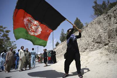 An Afghan man waves a national flag to celebrate the 102nd Independence Day of Afghanistan in Kabul on August 19, 2021, days after the Taliban's military takeover of the country. AFP