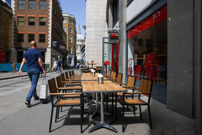 Empty terrace tables in the sunshine outside one of the restaurants still open in the City of London. Bloomberg