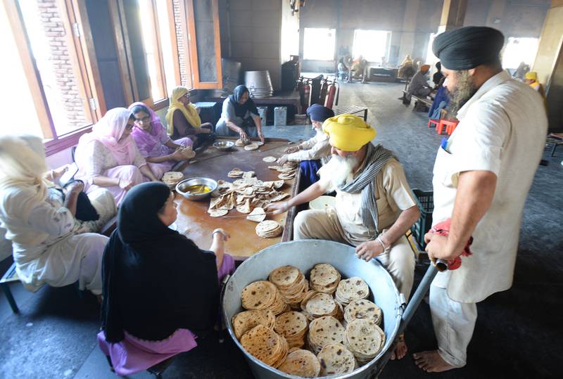 Women and men patiently making chapatis, the Indian flat bread—on large rectangle stoves—to feed 100,000 people. Photo: Taniya Dutta / The National