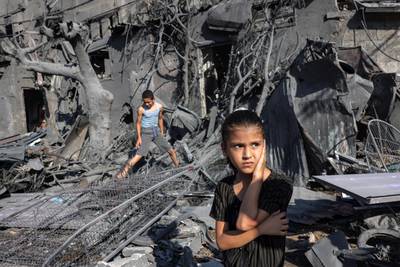 A girl stands by the rubble outside a building that was hit by Israeli bombardment in Rafah, Gaza. AFP