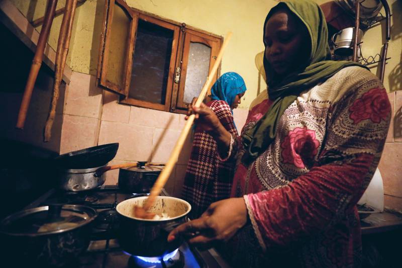 Sudanese refugee Ayat Mohamed cooks in the kitchen with her eldest daughter in Cairo. Reuters