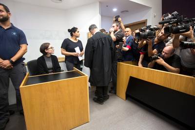American Lara Alqasem, left, sits in a courtroom prior to a hearing at the district court in Tel Aviv, Israel, Thursday, Oct. 11, 2018. A senior Israeli cabinet minister on Wednesday defended the government's handling of the case of an American graduate student held in detention at the country's international airport for the past week over allegations that she promotes a boycott against the Jewish state. (AP Photo/Sebastian Scheiner)