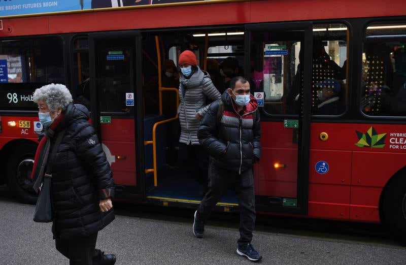 Masked travellers get off a bus in London.  According to his official spokesperson in Downing Street, Mr Johnson has told his cabinet that the Omicron variant of coronavirus appears to be more transmissible. EPA