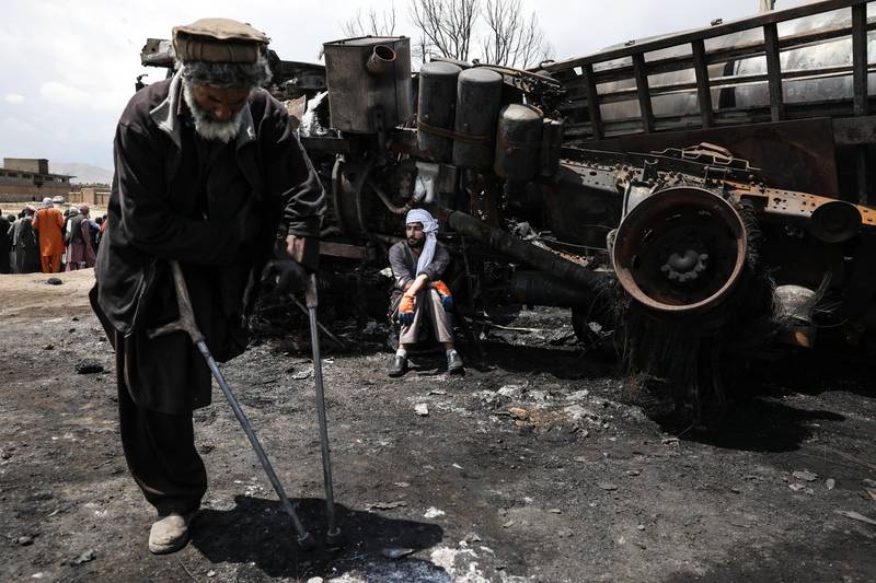 An Afghan driver sits near to his burnt tanker. EPA