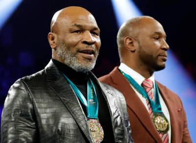 Former heavyweight champions Mike Tyson and Lennox Lewis in the ring.