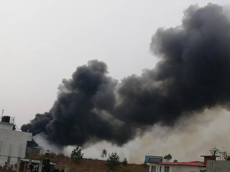 Smoke rises following the crash of a Bangladeshi aircraft at Kathmandu airport, Nepal on March 12, 2018. Rusha Giri / via Reuters