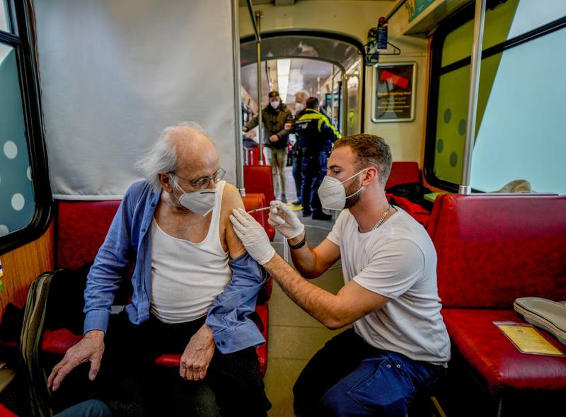 An 85-year-old man receives a booster vaccination aboard the ‘vaccination express’ tram in Frankfurt, Germany. AP