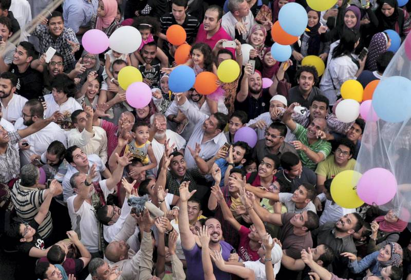 Egyptian Muslims release balloons at the end of prayers on the first day of Eid al-Fitr holiday that marks the end of the holy fasting month of Ramadan on June 25, 2017, in the northeastern suburb of Sheraton in the capital Cairo. / AFP PHOTO / SAMER ABDULLAH