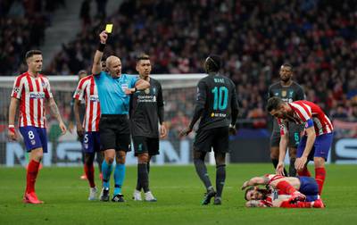 Liverpool's Sadio Mane is shown a yellow card by referee Szymon Marciniak. Reuters