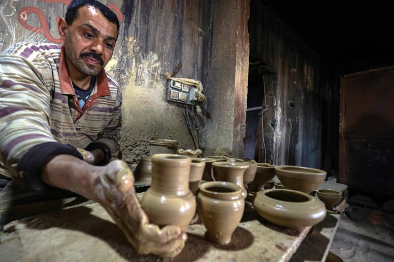 A potter makes ceramic pots at a workshop in the town of Gharyan, about 100 km (60 miles) southwest of the capital Tripoli, on February 5, 2022.  - Gharyan sculpted a reputation for ceramics generations ago, but fragile demand is forcing potters to seek new markets on Instagram and Facebook.  (Photo by Mahmud TURKIA  /  AFP)