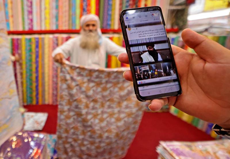 An Afghan cloth merchant in Dubai gets updates on the situation in Kabul, on August 18. AFP