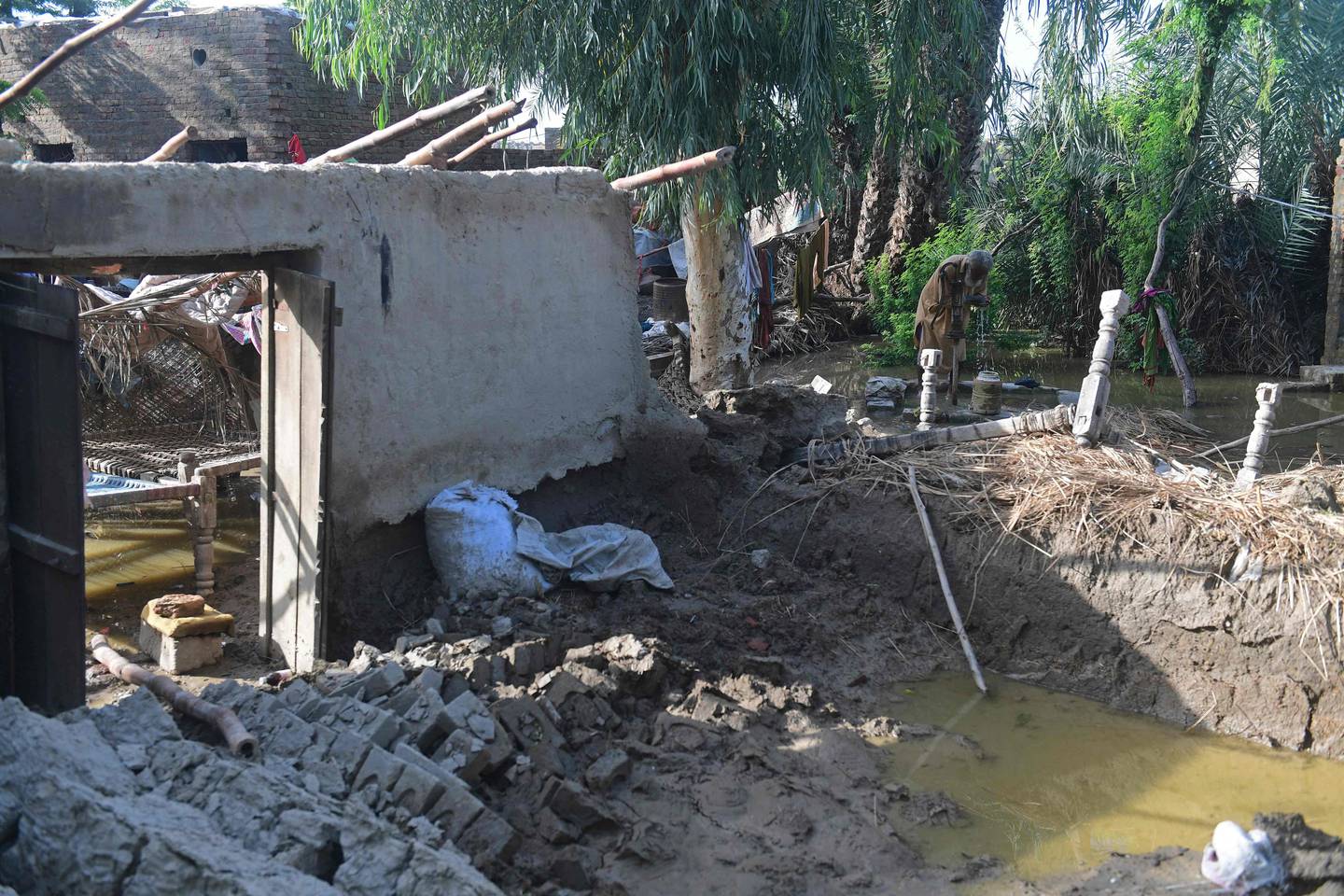 Ghulam Rasool uses a handpump next to his flood-damaged mud house on the outskirts of Sukkur, Sindh province. AFP