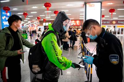 A passenger wearing a face mask as he shows a green QR code on his phone to show his health status to security upon arrival at Wenzhou railway station in Wenzhou. The National Health Commission on March 1 reported 573 new infections, bringing the total number of cases in mainland China to 79,824. AFP