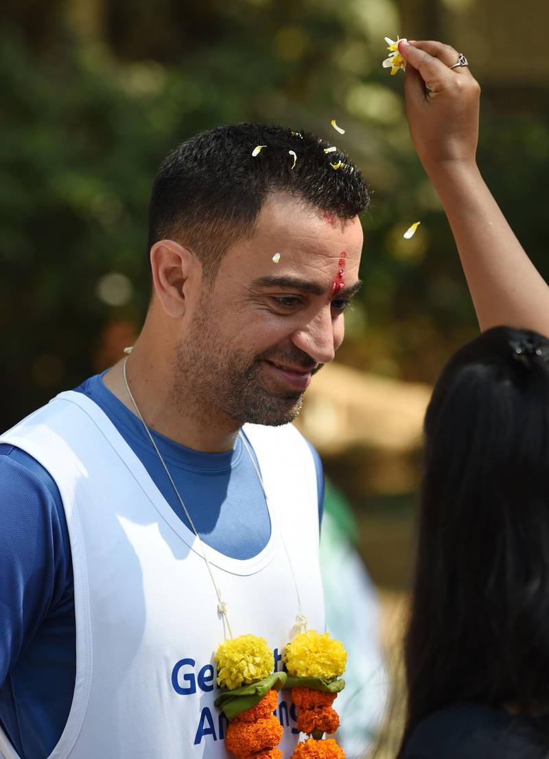 Former Barcelona and Spain midfielder Xavi is welcomed during the ground breaking ceremony of an astro-turf football pitch in Mumbai.