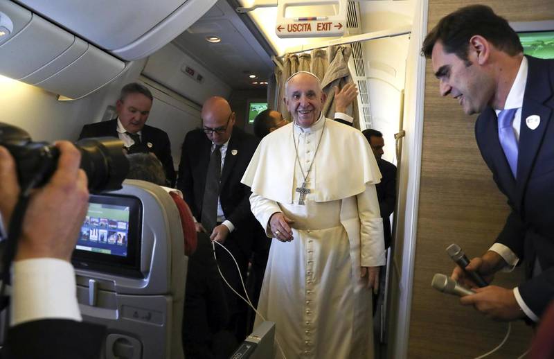 Pope Francis speaks to reporters aboard a plane on the way to Abu Dhabi. EPA