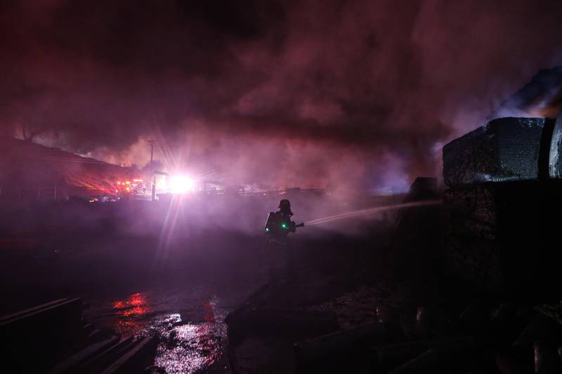 A firefighter works at an industrial facility heavily damaged by the Tick Fire in Canyon Country. AFP
