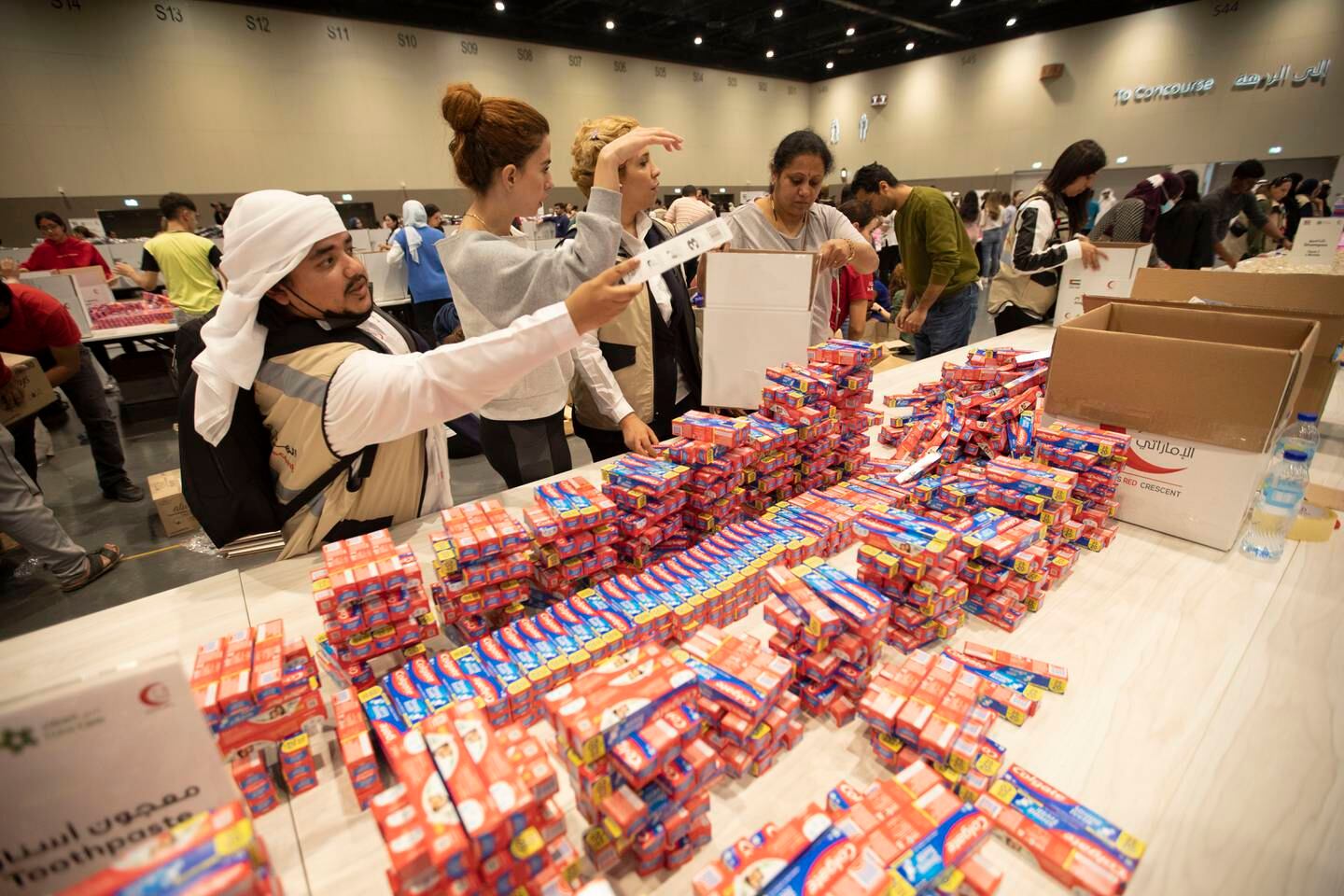 Des volontaires emballent l'essentiel lors de l'événement Bridges of Goodness à Expo City, Dubaï.  Leslie Pableo pour The National